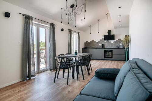 a living room with a couch and a table and chairs at Apartments Muller in Mlini