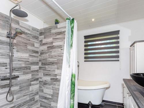 a bathroom with a shower with a toilet and a sink at Holiday home Løgstør IX in Løgstør