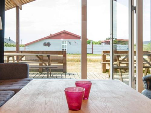 a wooden table with two cups on top of it at 4 person holiday home in Harbo re in Harboør