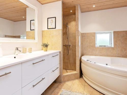 uma casa de banho com uma banheira, um lavatório e um chuveiro em Holiday home Otterup XXIV em Otterup