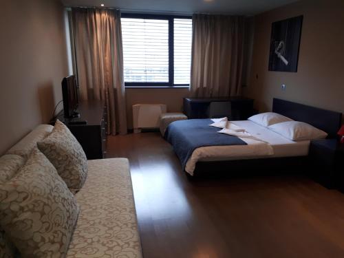 a hotel room with a bed and a couch at Nitro Rooms in Ljubljana