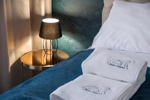 een bed met twee handdoeken erop bij Baltic Gdańsk OLD TOWN by St Mary s Church in Gdańsk