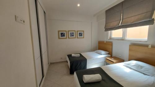 een kleine slaapkamer met 2 bedden en een raam bij CLC Wyndham Kuşadası Golf resort in Soke