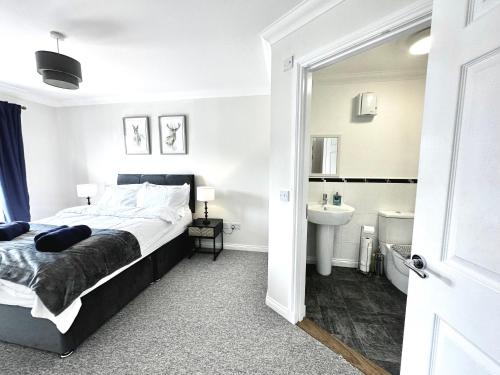 a bedroom with a bed and a bathroom with a sink at Riverview Apartment 2 bed, 2 bath, Free Parking / WiFi in Inverness
