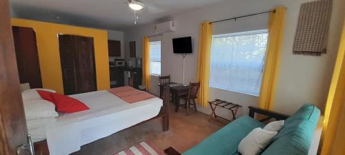 a hotel room with a bed and a couch at Amanda's Place Yellow Studio - Pool and Tropical garden in Caye Caulker
