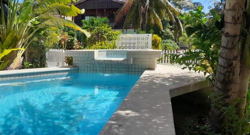 a swimming pool with blue water in a yard at Amanda's Place Yellow Studio - Pool and Tropical garden in Caye Caulker