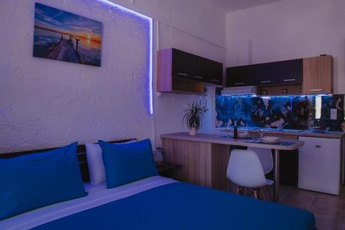 a bedroom with a blue bed and a kitchen at AkoumiaStudio in Akoumia