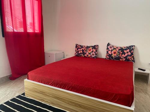 a bedroom with a bed with a red bedspread at RESIDENCE EL HADJI in Dakar