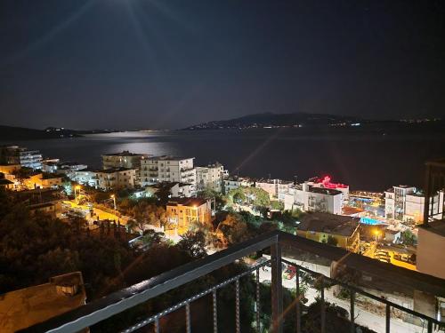 a view of a city at night with the water at Joanna Suites in Sarandë