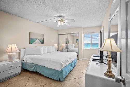 a bedroom with a bed with a ceiling fan at Holiday Surf and Racquet Unit 520 in Destin