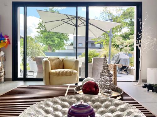- un salon avec une table et un parasol dans l'établissement VILLA TROPICALE - Plages à 5 min, à Concarneau