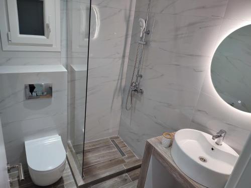 a bathroom with a toilet and a sink and a shower at Alexander Luxury Apartments & Studios in Metamorfosi