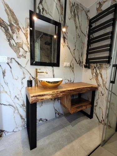 uma casa de banho com um lavatório de madeira e um espelho em LoveLake dom z jacuzzi em Radzyń