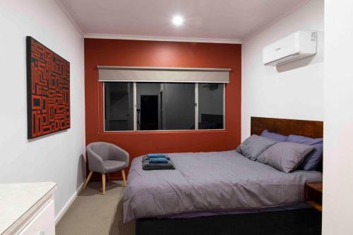 a bedroom with a bed and a red wall at 4 Bedrooms, 2 Bathrooms in Alice Springs in Alice Springs