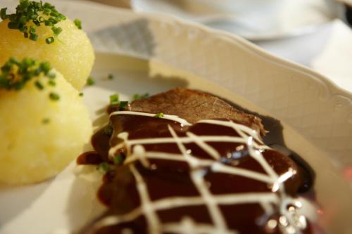 a plate of food with a piece of meat and chocolate at Hotel Restaurant Lohmühle in Bayreuth