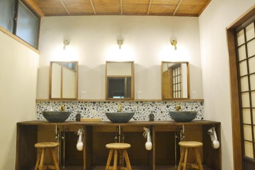a bathroom with three sinks and three mirrors at 野窓 Nomadノマド Tsuwano GuestHouse & Cafe Lounge in Tsuwano