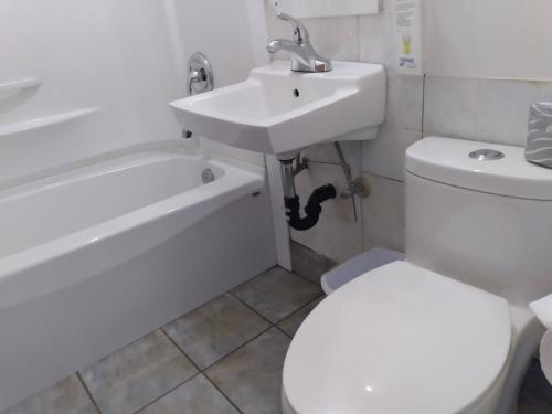 a bathroom with a white toilet and a sink at Dolphin Motel in Tofino