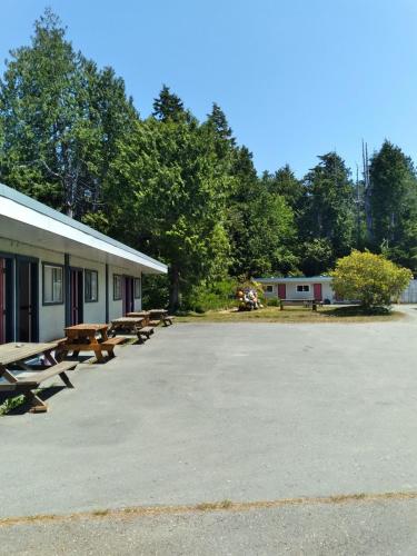 a group of picnic tables in front of a building at Dolphin Motel in Tofino