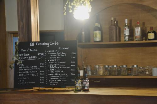 a bar with a sign and bottles of alcohol at 野窓 Nomadノマド Tsuwano GuestHouse & Cafe Lounge in Tsuwano