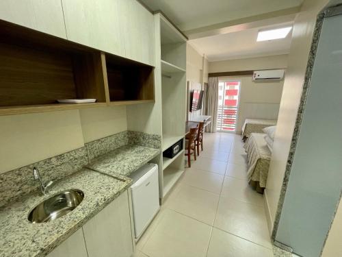 a kitchen with a sink and a room with a bed at Spazzio diRoma com acesso ao Acqua Park, Splash e Slide in Caldas Novas