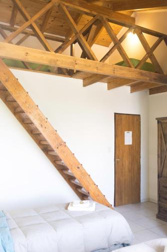 a bedroom with a bed and a wooden ceiling at Tranqueras Lodge in El Chalten