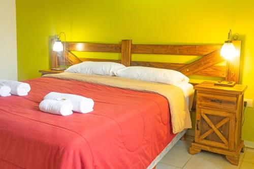 a bedroom with a bed with two folded towels on it at Tranqueras Lodge in El Chalten