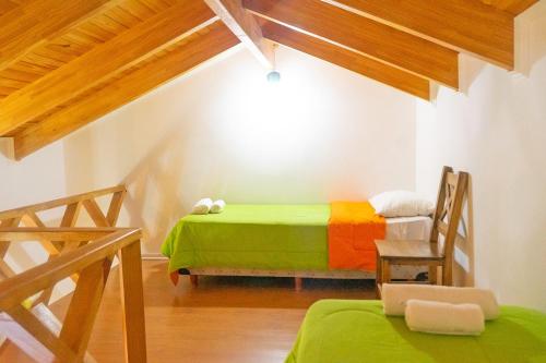 a bedroom with a bed and a chair in a room at Tranqueras Lodge in El Chalten