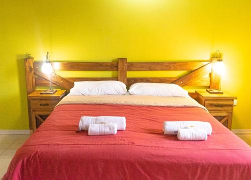 a bedroom with a large bed with two towels on it at Tranqueras Lodge in El Chalten