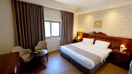 um quarto de hotel com uma cama, uma secretária e uma janela em Christmas Hotel - Jerusalem em Jerusalém