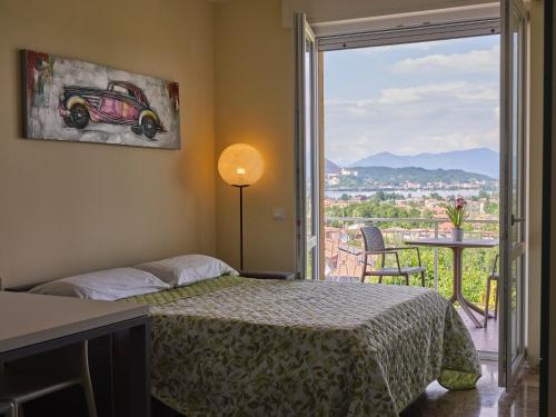 Un dormitorio con una cama y una ventana grande. en Casa Ierardi - Appartamento Arona Bellavista, en Arona