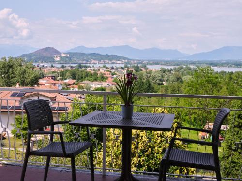 Una mesa y sillas en un balcón con vista. en Casa Ierardi - Appartamento Arona Bellavista, en Arona