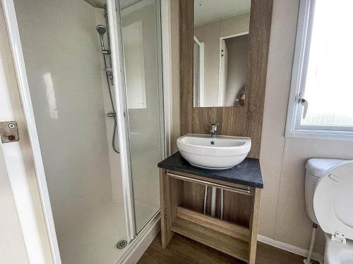 a bathroom with a sink and a shower and a toilet at Modern 6 Berth Caravan With Wifi At St Osyth Beach In Essex Ref 28051fv in Clacton-on-Sea