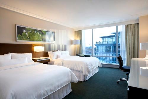 um quarto de hotel com duas camas e uma grande janela em The Westin Wall Centre, Vancouver Airport em Richmond