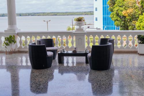 a patio with chairs and a table and a fence at Hotel Estación by Destino Pacifico in Buenaventura