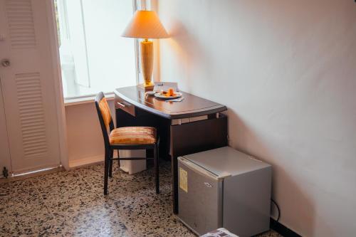 a desk with a lamp and a chair next to a window at Hotel Estación by Destino Pacifico in Buenaventura