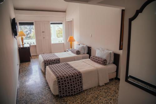 a hotel room with two beds and a window at Hotel Estación by Destino Pacifico in Buenaventura