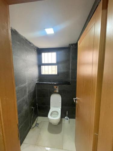 a bathroom with a toilet and a window at Maison Lapierre d'agadir in Agadir