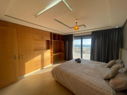 a bedroom with a bed and a large window at Maison Lapierre d'agadir in Agadir