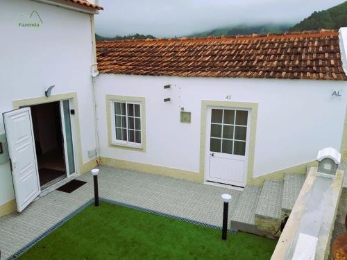 a white house with two doors and a yard at Fazenda Valley in Santa Cruz das Flores