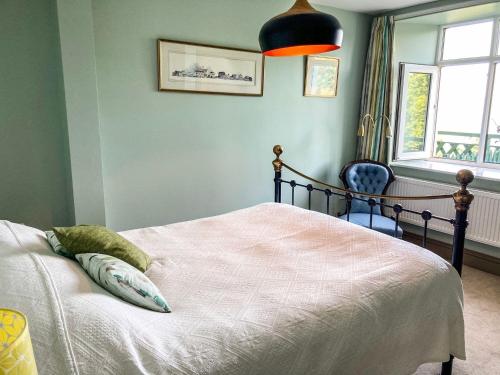 a bedroom with a bed and a chair and a window at North Walk House in Lynton
