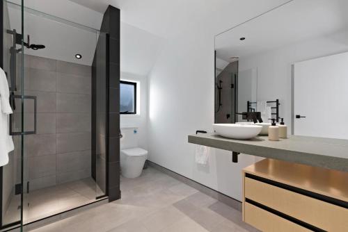 a bathroom with a sink and a glass shower at Cardrona Creekside Apartment in Cardrona