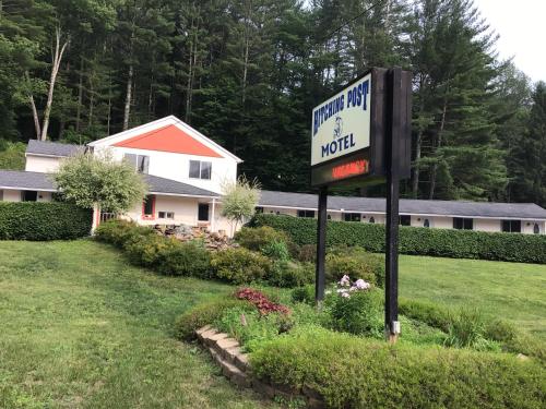 a sign for a hotel next to a house at Hitching Post Motel in Cornwall