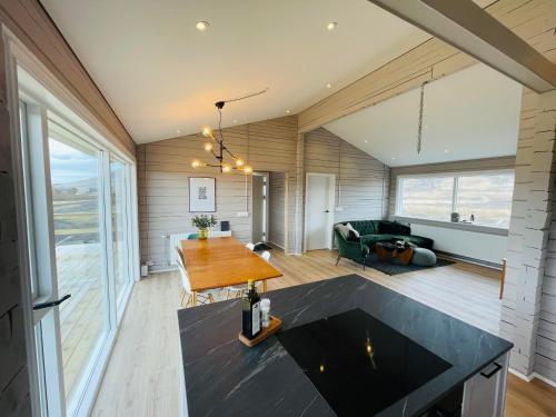 ein Wohnzimmer mit einem Tisch und einem Sofa in der Unterkunft Stylish cottage with hot tub in Stóri-Ás