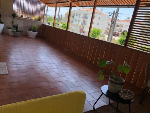 Balcón con sofá, mesa y ventanas en Pombal Suite, en Pombal