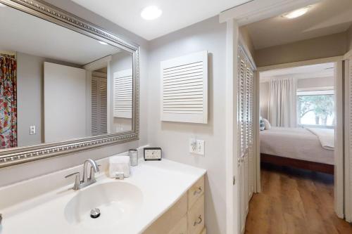 费南迪纳比奇Sea Marsh Retreat Condo in Fernandina Beach in a gated community的带水槽、镜子和床的浴室
