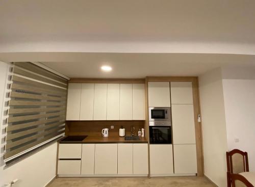 una cucina con armadi bianchi e piano di lavoro di Tregu fatoni prizren apartment 3bedroom a Prizren