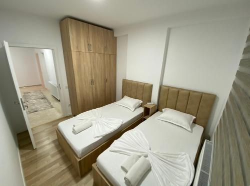 2 Betten in einem kleinen Zimmer mit Spiegel in der Unterkunft Tregu fatoni prizren apartment 3bedroom in Prizren