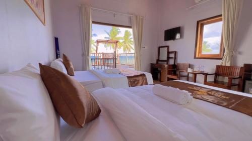 a hotel room with two beds and a balcony at The Poplar Resort Phú Quốc in Phu Quoc