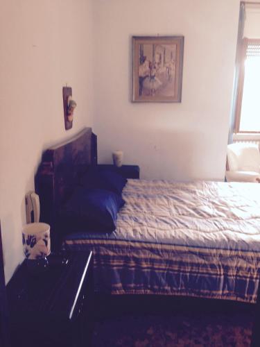 a bedroom with a bed and a chair and a window at Stanza Bellaria in Pontedera