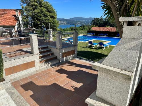 une maison avec une terrasse et une piscine dans l'établissement Apartamentos Naturmar, à Raxo